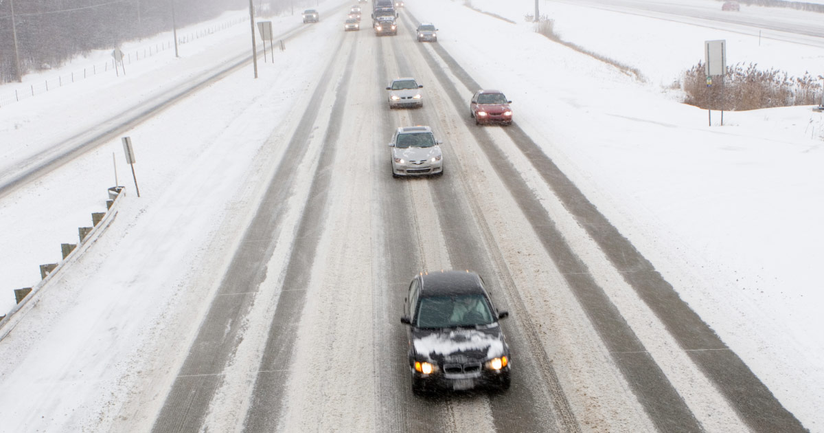 Cars and trucks driving on snow covered highway