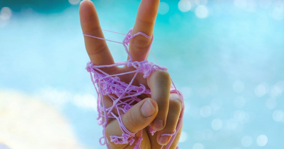 Kid making peace sign with hand covered in silly string