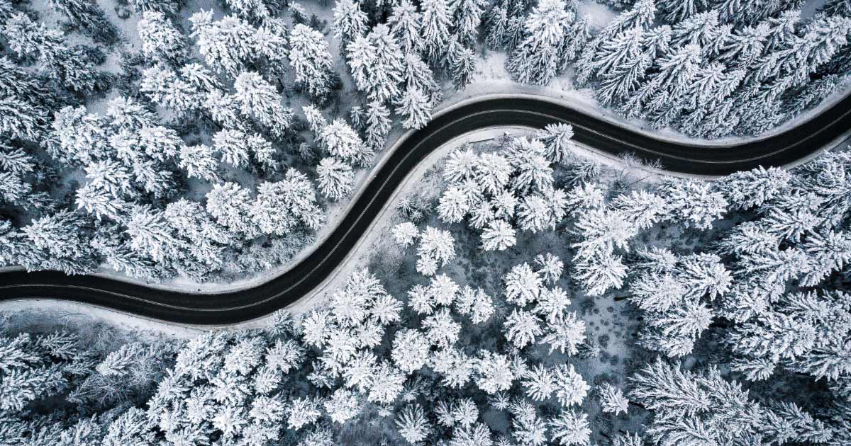 Overhead shot of windy mountain road and snow covered trees